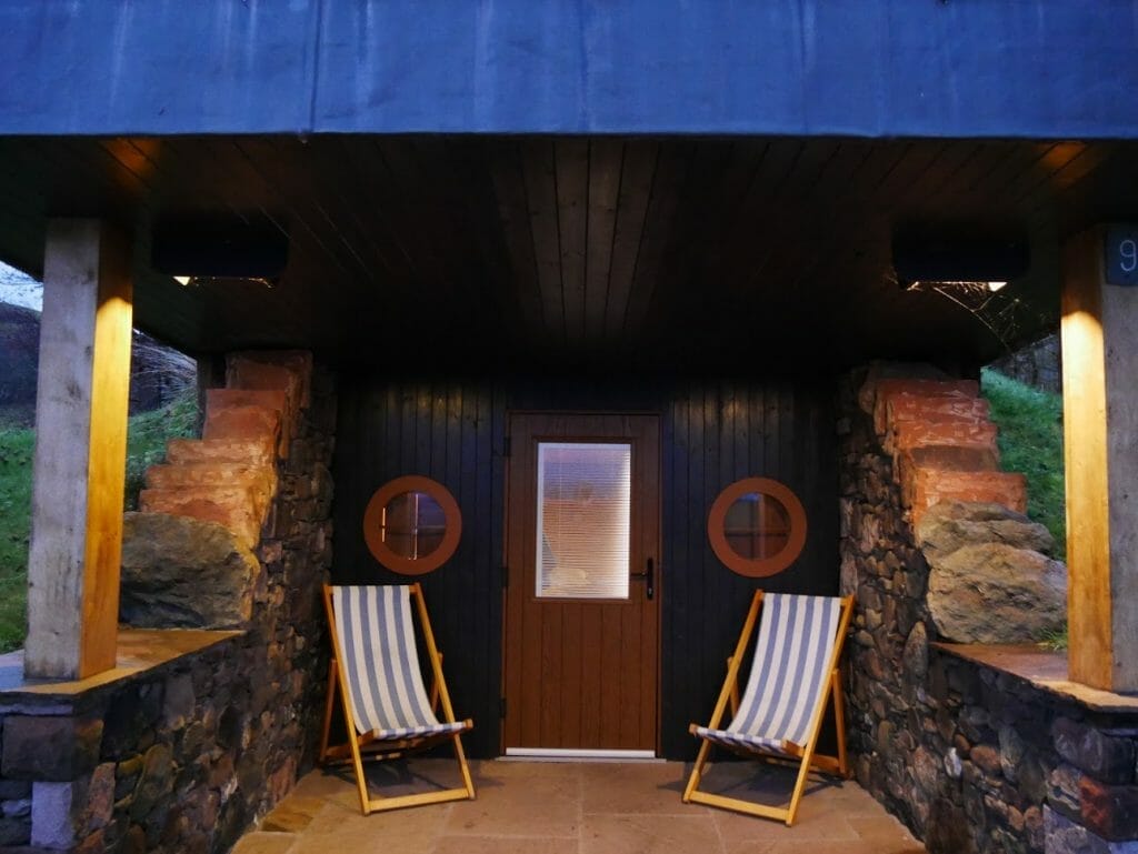 Deck chairs on the porch of a hobbit hole at The Quiet Site Ullswater