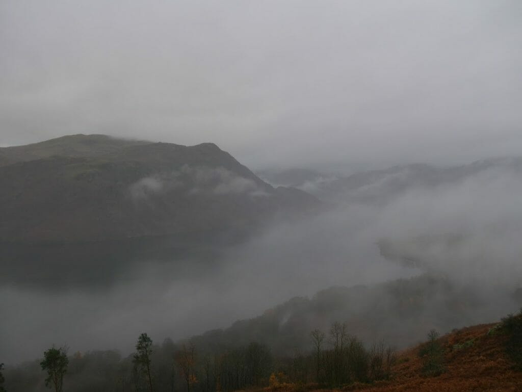 A view over Ullswater from the top of a hill with lots of fog