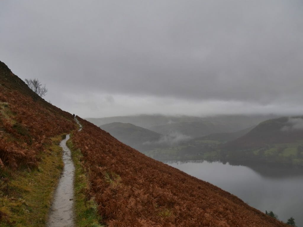 Path along a hillside next to Ullswater with cloudy skies