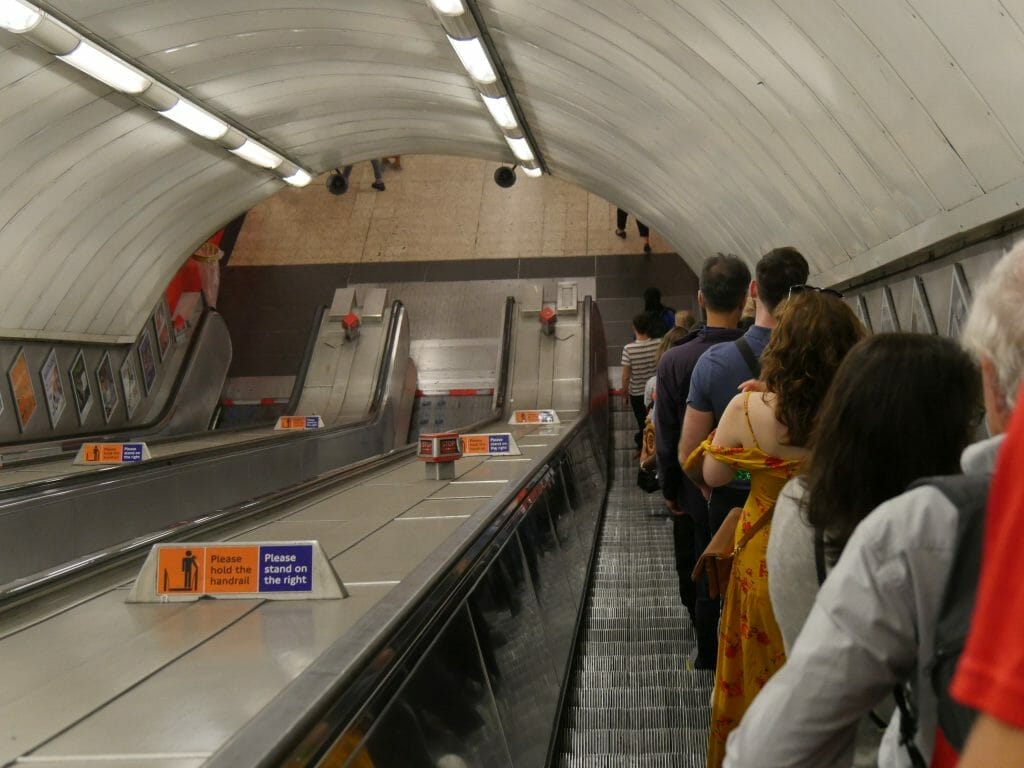 People standing on the right of an escalator on the tube underground in London