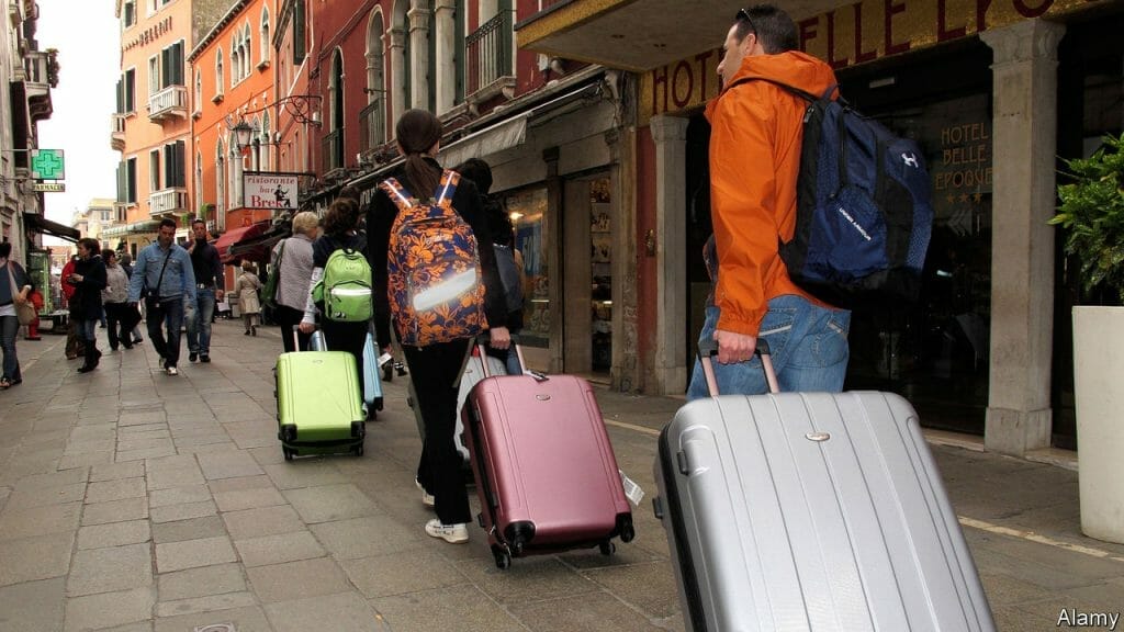 Tourists with Luggage walking down a street