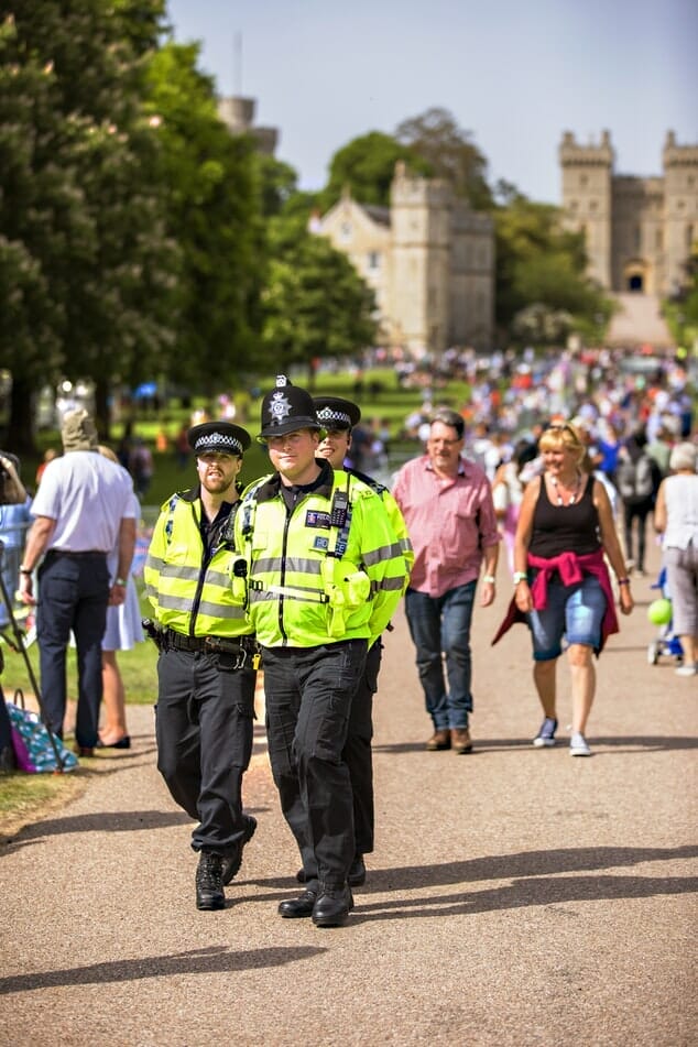 Police walking outside Windsor Castle with crows, in high-visibility jackets and no guns