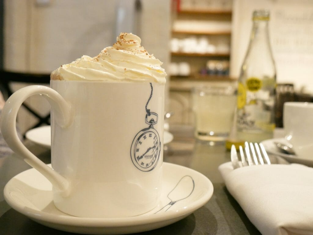 A hot chocolate in a mug with whipped cream on top