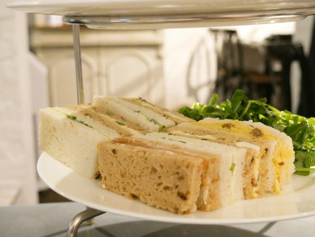 Two sandwiches on a plate with greenery