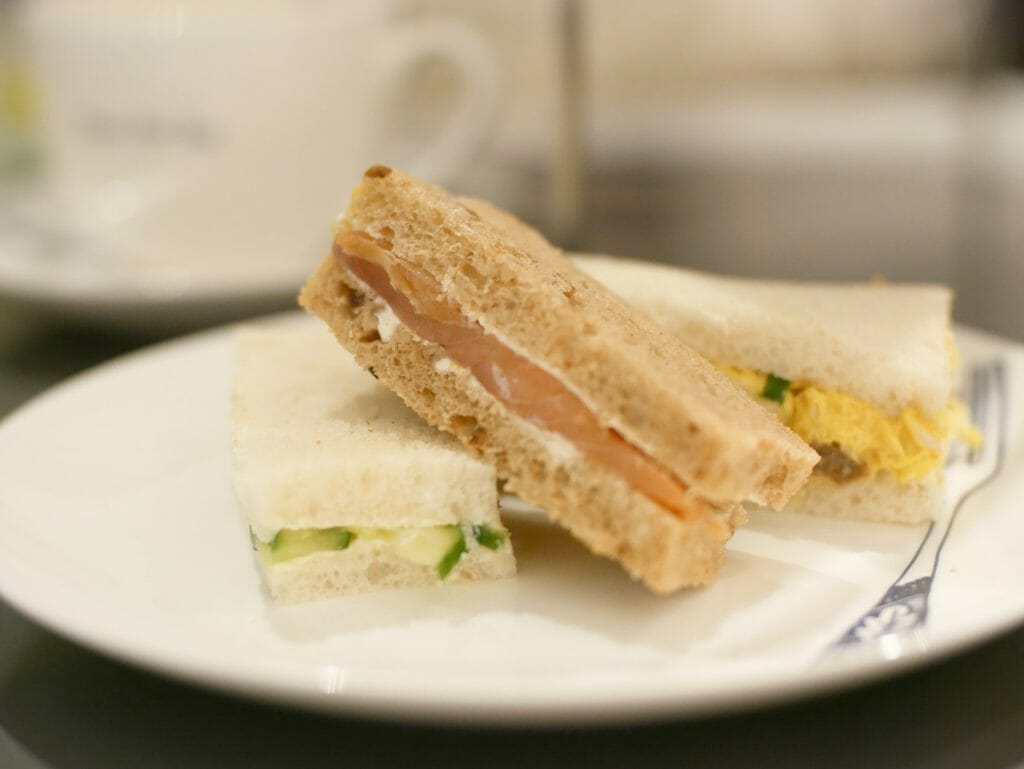 Three sandwiches neatly stacked on a plate