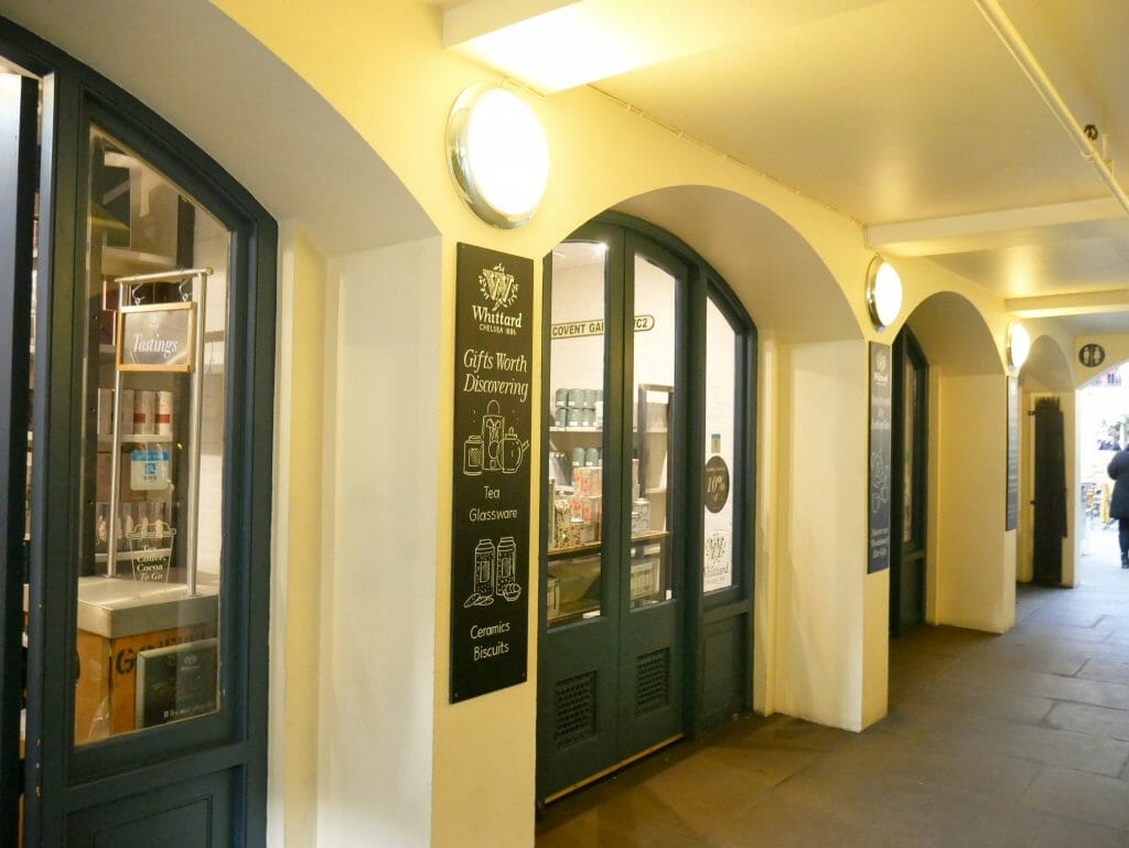 The entrance to Whittards afternoon tea room on the lower floor of Covent Garden with arches over green doors and windows