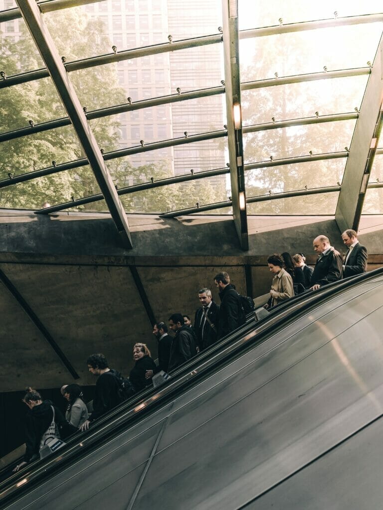 people walking down tube escalator