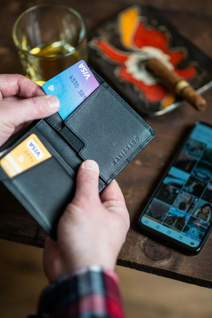 man pulling credit card out of wallet