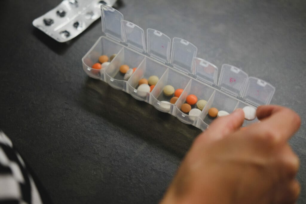 hand putting pills into medication sorter