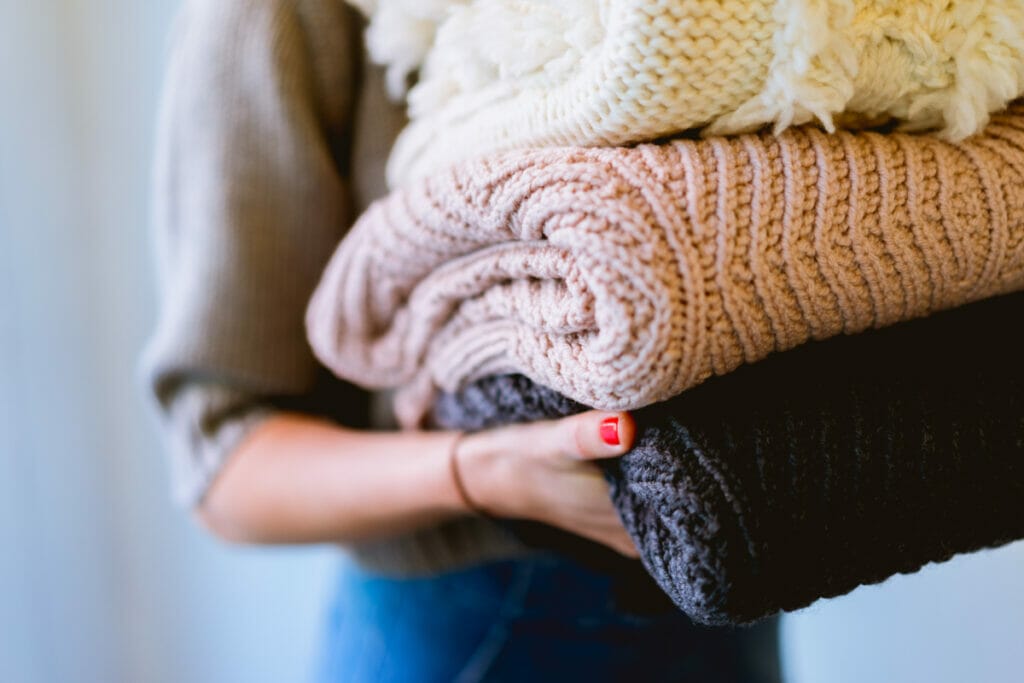 woman carrying heavy blankets