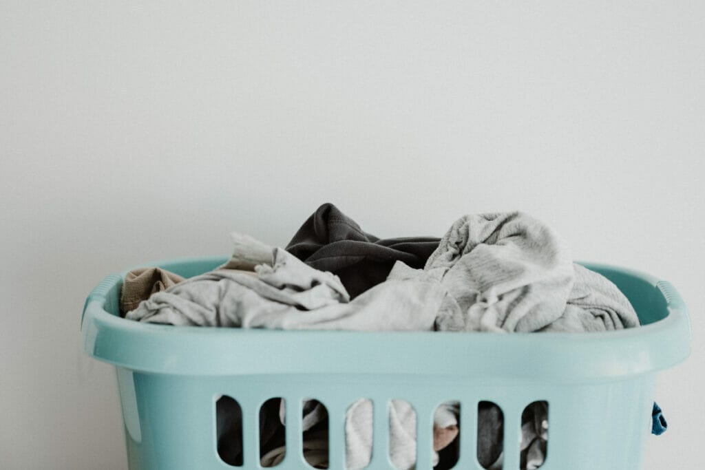 basket of dirty laundry in blue hamper